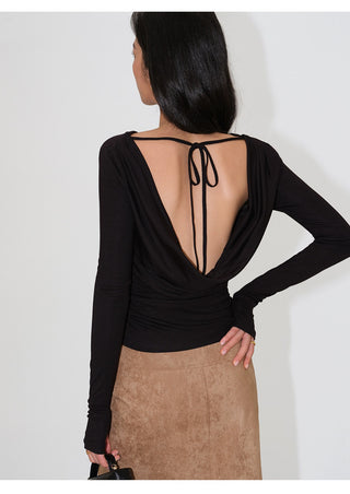 Side-back view of muted green draped open-back long-sleeve top