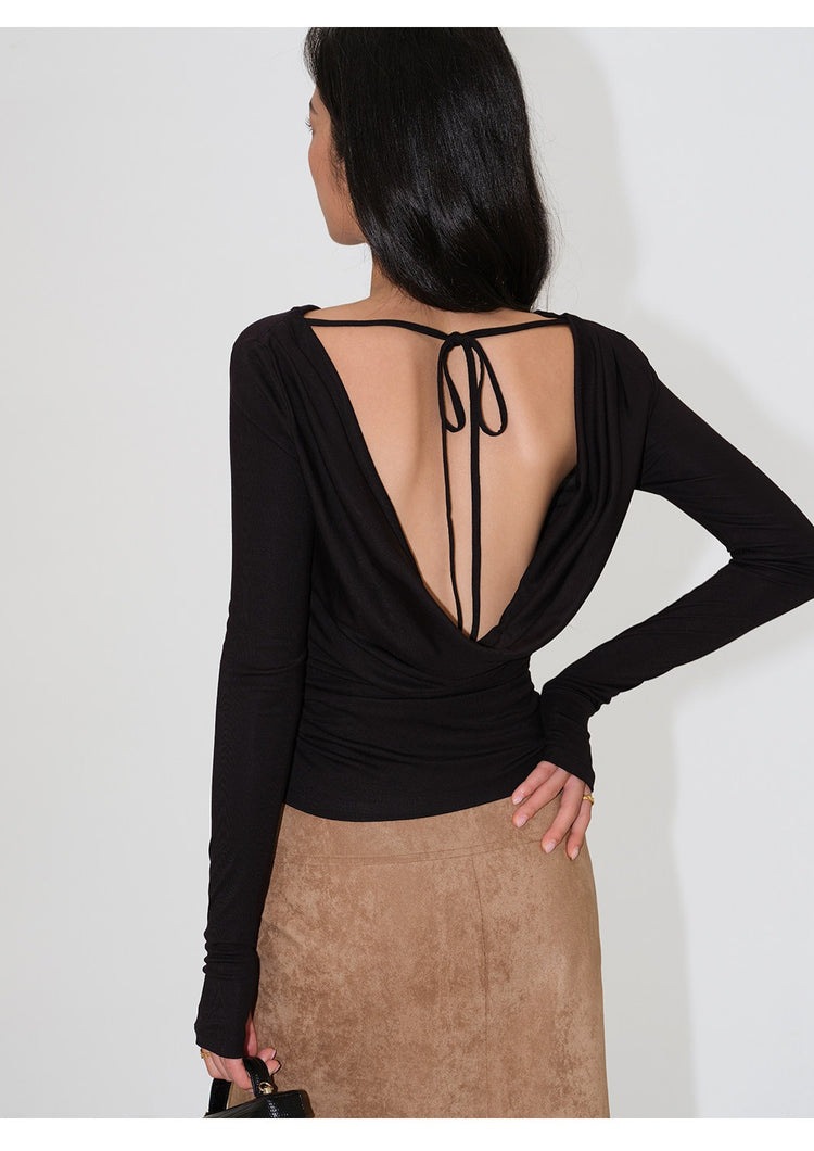 Side-back view of muted green draped open-back long-sleeve top