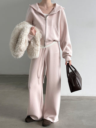 Pale pink hoodie showing relaxed sleeves and front pocket details