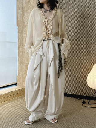 Layered balloon pants styled with a cream ruffled blouse and sandals