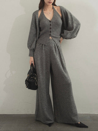 Model wearing a black three-piece knit set with a button-front top and wide-leg pants