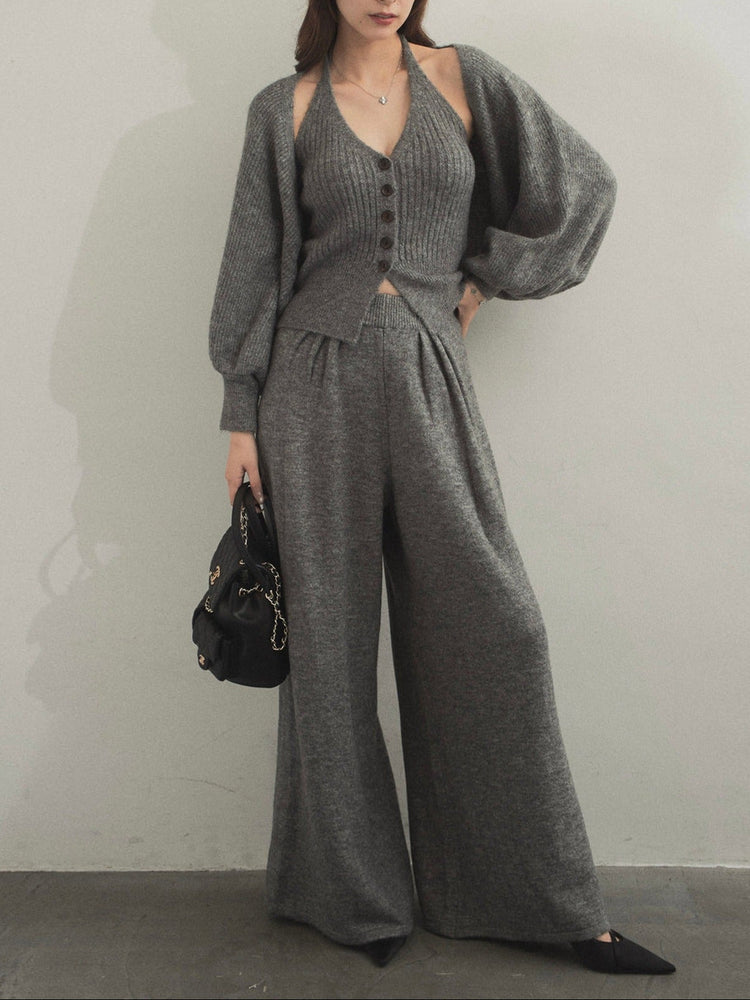 Model wearing a black three-piece knit set with a button-front top and wide-leg pants