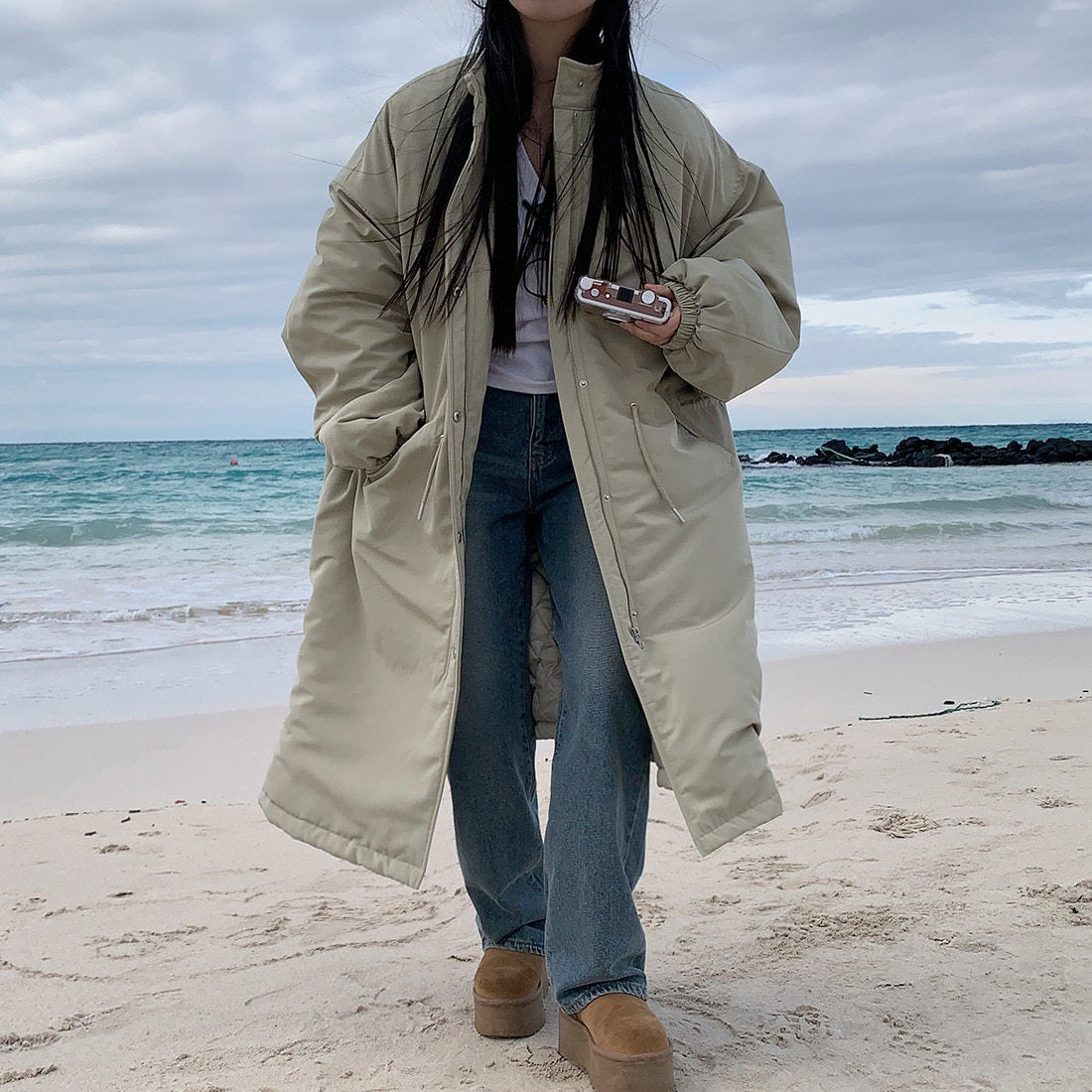Light khaki longline parka with side pockets and gathered cuffs