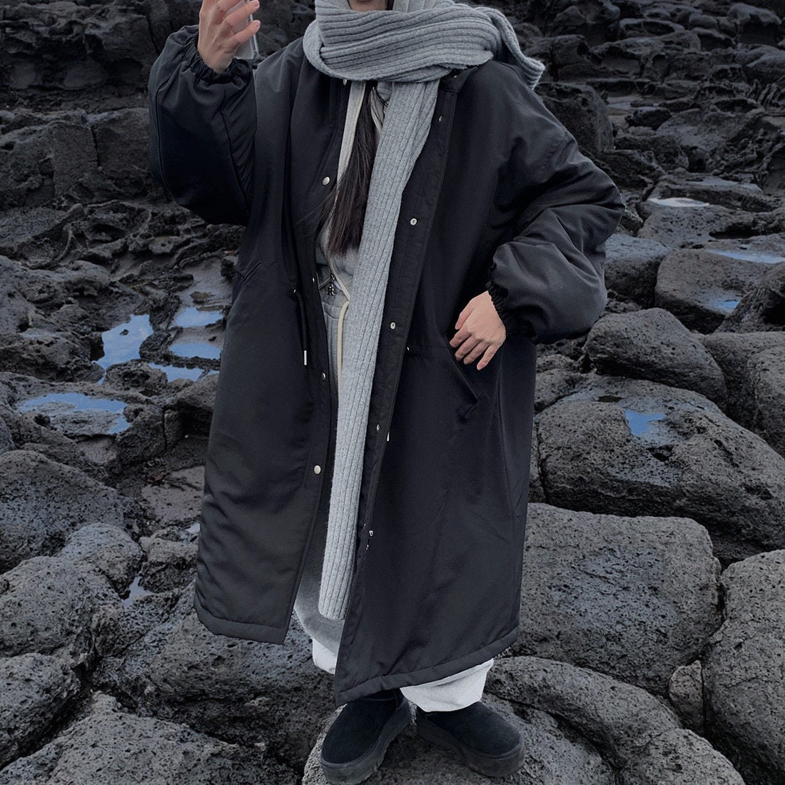 Black longline parka styled with a grey scarf, scarf not included