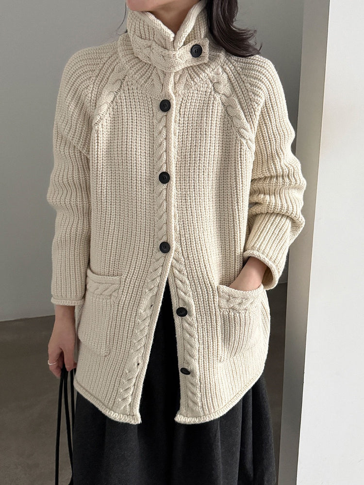 Ivory high-neck cable knit cardigan with dark buttons and front patch pockets
