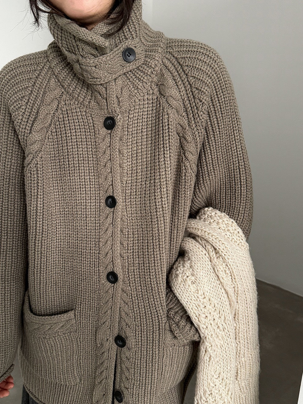 Close-up of taupe cardigan collar, buttons and knit texture