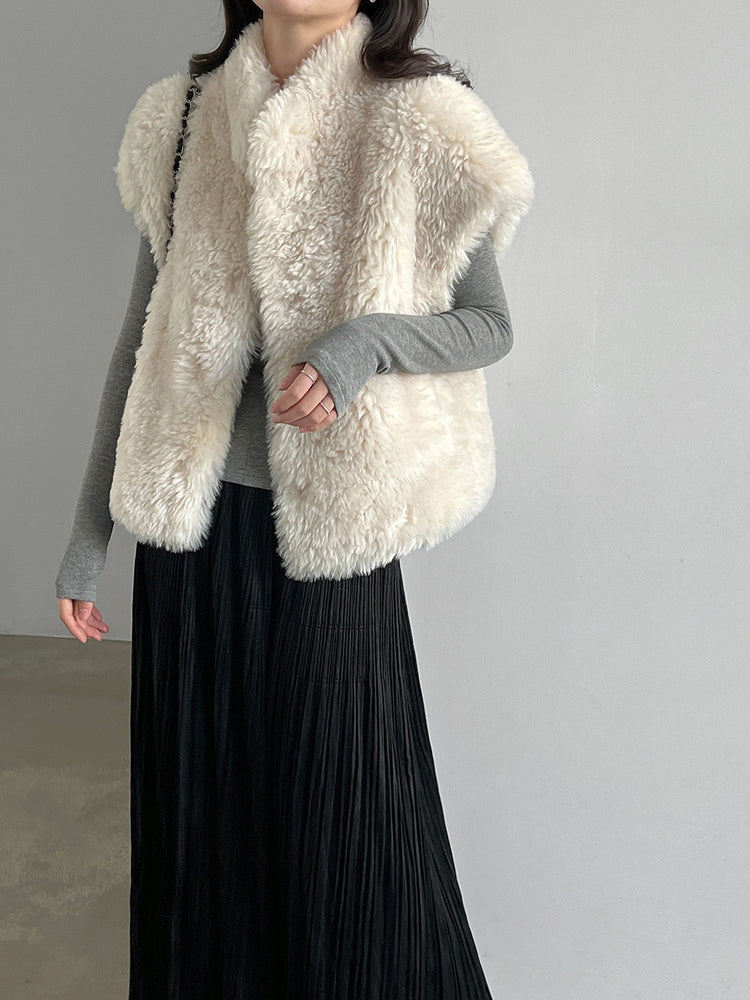 Ivory faux shearling vest worn over a grey top