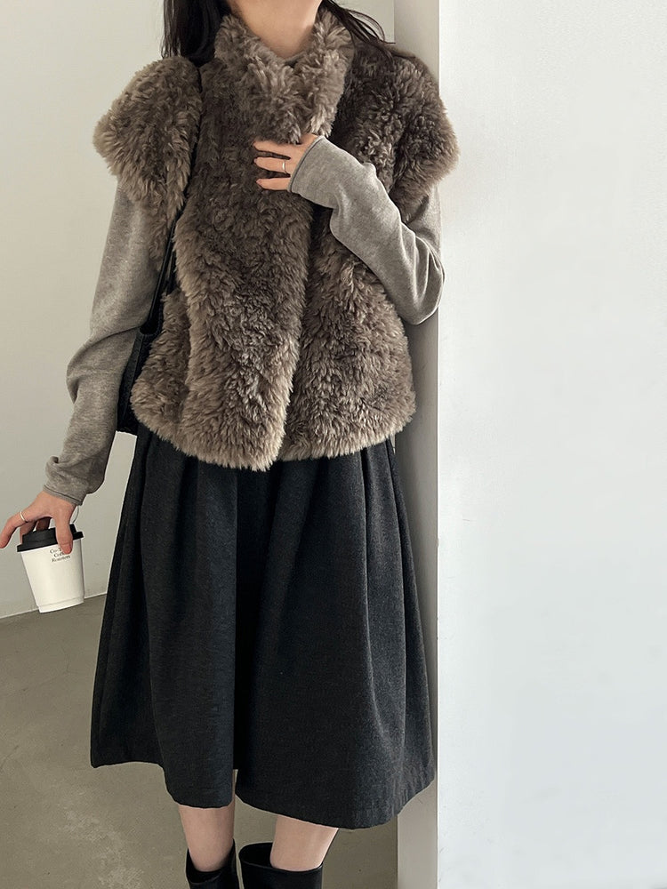 Taupe plush faux shearling vest styled over a long-sleeved top